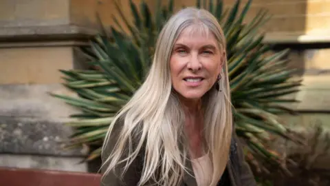 Getty Images Sharron Davies has long, blonde hair. She is smiling at the camera 