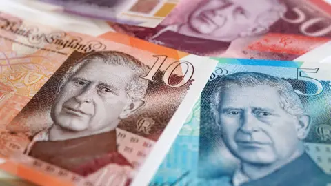 PA Media Three bank notes of the value of £5, £10 and £50 featuring the face of King Charles III