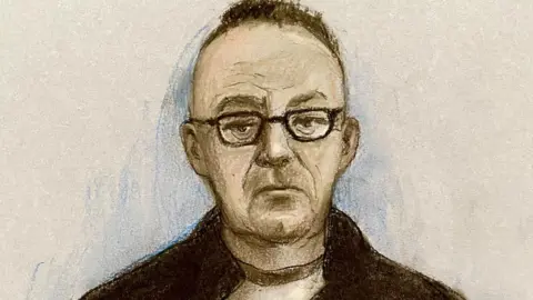 Elizabeth Cook/PA A court sketch artist's impression of Gary Poland, who is wearing a pair of black rimmed glasses and a black jacket, and has dark hair shaved at the sides and longer on top. 