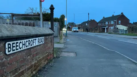 BBC Image of Beechcroft road just after dusk. The all on the left has the Beechcroft Road sign on it. 