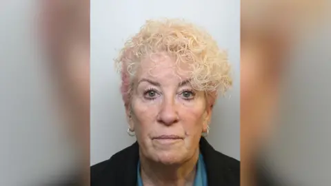 Mugshot of blonde hair wearing hoop earrings.