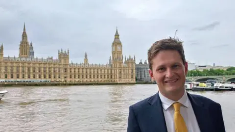 David Chadwick David Chadwick with Westminster in the background across the river.
