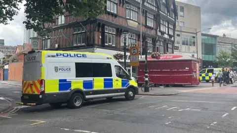 BBC A general view picture of a police van parked up in Hosier Street, Reading, which is partly cordoned off with police tape.