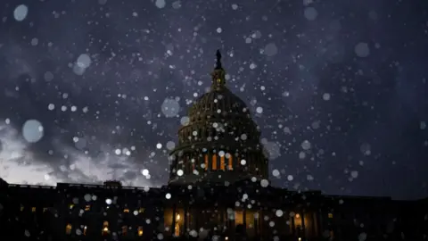 Snow falls outside the US Capitol