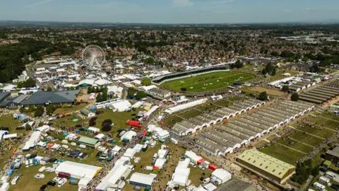 Great Yorkshire Show An aerial view of the Great Yorkshire Show. Large white tents can be seen dotted around with a large grassy show area and a big wheel visible in the distance.