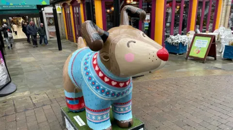 A sculpture of a cartoon snow dog stood outside Spring Gardens in Buxton