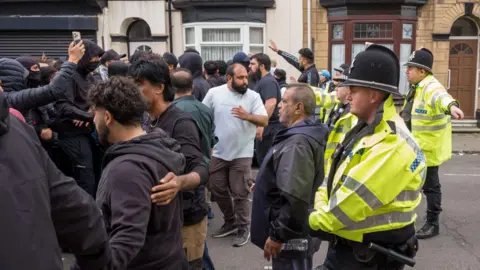 Getty Images A group of men protect a mosque 