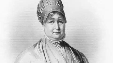 Getty Images A black and white line portrait of Elizabeth Fry. She wears a turban-style hat and her hair curls over her forehead. The high collar of her shirt reaches around her neck and her dress is crossed over the chest, revealing a lighter colored shirt underneath.