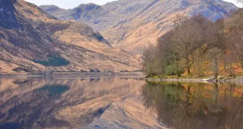 Kirsty Sweeting  Loch Sheil at Glenfinnan - a loch with mountains and trees beyond it