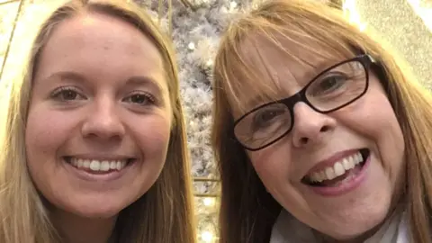 Poppy Devey Waterhouse and her mother Julie Devey taking a selfie. They are looking into the camera and smiling.