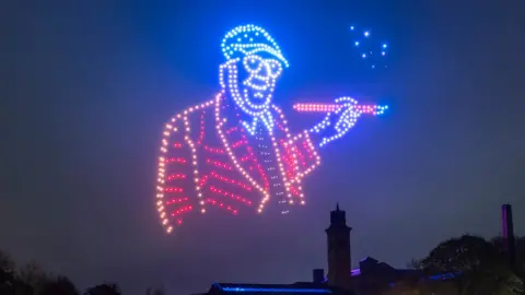 Danny Lawson/PA Colourful lights in a dark sky paint a picture of David Hockney