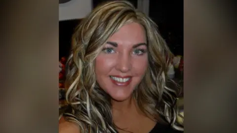 A handout image of Rachel Simpson. She is taking a selfie and has blonde, highlighted, curled hair. She is smiling at the camera.
