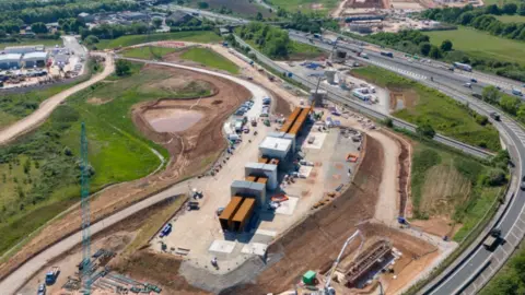  Aerial view a construction site by the side of a motorway
