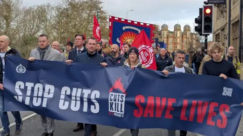 FBU members holding a banner whilst marching through Oxford.