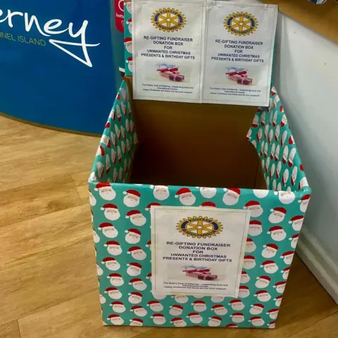 Vaughan Davies/Rotary Club of Alderney A large empty box is wrapped in green Christmas Christmas paper. It has a poster on it appealing for unwanted gifts.