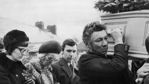 Getty Images Lesley's brother Ron looking at the camera in a black and white photograph on the day of her funeral.