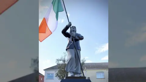 The statue of Bobby Sands holding an Irish flag