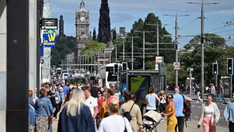 People walk on a crowded shopping street in Edinburgh