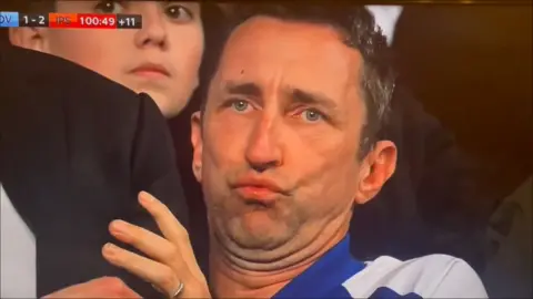 Sky Sports Rob Farmer pouts as he holds onto a friend