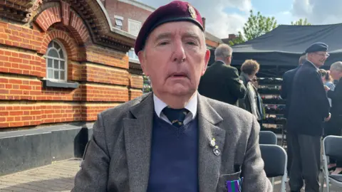Julia Gregory/BBC Close up shot of Keith Ovens, 89, attending a ceremony in Epsom wearing a beret and medals.