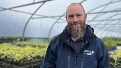 Biodiversity officer Liam Blazey standing in polytunnel 