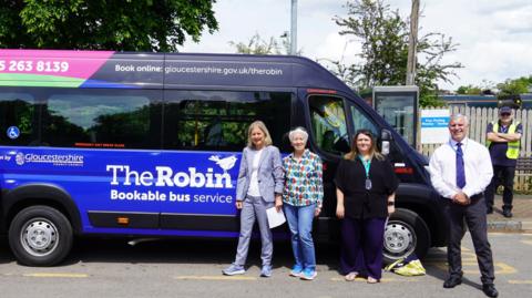 Four people stood by The Robin bus