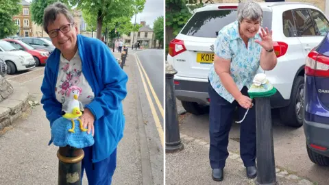 A composite image of two women putting knitted yarn bombs on bollards. The woman on the left is wearing a blue jacket stands by a bollard displaying a crocheted cover topped with a bird figure and a small duck.
The woman on the right is leaning towards a bollard, adjusting a striped crocheted cover, with parked cars lining the street behind.