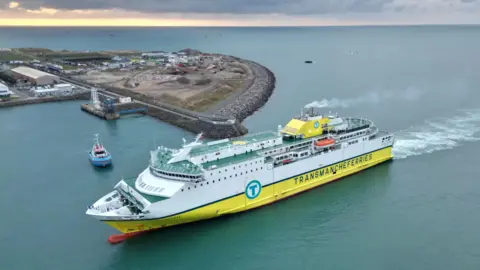 BBC Ferry with a tugboat nearby heading towards a berthing trial in Jersey's St Helier Harbour