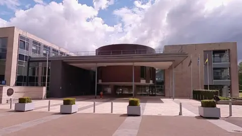 The outside of Livingston Sheriff Court, a modern building with a circular centre and small pillars atthe front