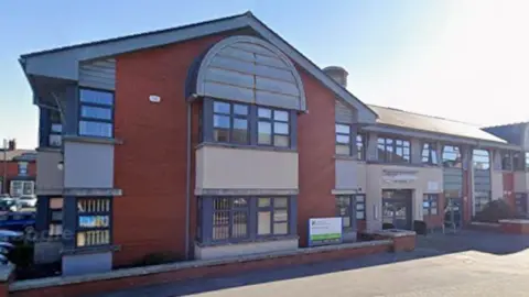 Google Adelaide Surgery's Gorton Street practice in Blackpool. It is a long two-storey redbrick and cream-rendered modern building.