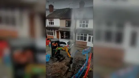 Water shooting up in the air from a burst pipe
