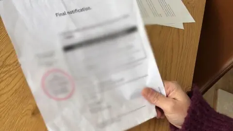 One hand holds a letter in blurred handwriting. It says final notification at the top of the letter