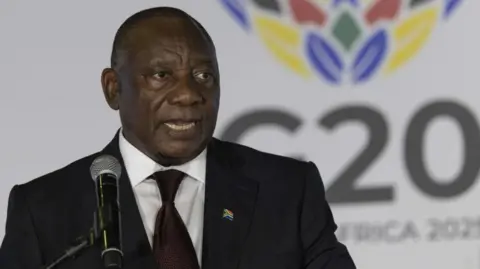 Cyril Ramaphosa in a dark suit and tie addresses the media during a G20 Foreign Ministers meeting.