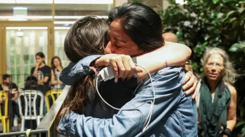 Reuters Einav Zangauker, the mother of hostage Matan Zangauker, is hugged by another woman after Trump's announcement