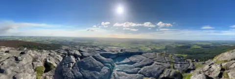 Lynne Davidson A panoramic picture taken from the top of a hill looking over fields