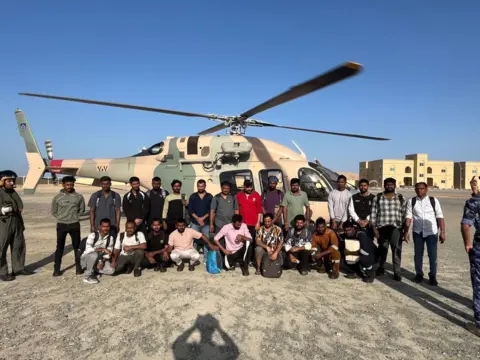 FSUI A group of men standing in front of a helicopter