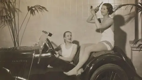 Getty Images 1934
Mannequins display to help sell cars at Whiteleys Motor Show, 1934. Bathing beauties help to sell this sporting car. Photograph by James Jarche. (Photo by Daily Herald Archive/National Science & Media Museum/SSPL via Getty Images)