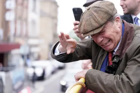 PA Nigel Farage flinches after an object is thrown at him.