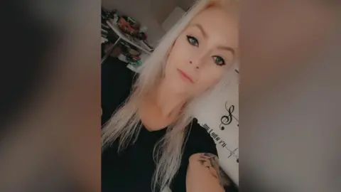 Nathalie te Wilt A selfie of a woman with blonde hair wearing a black t-shirt with a tattoo on her right arm.