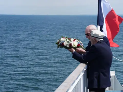 Jordan Pettitt/PA Media D-Day veterans Harry Birdsall, 98, and Alec Penstone (front), 98, throw a wreath into the sea 