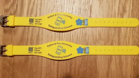Avon Fire and Rescue Two yellow wristbands with the words "police and fire dementia safeguarding scheme" on them