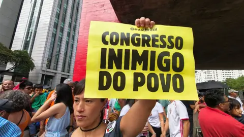 People gather during a demonstration to oppose the sentence-reduction bill, known as PL da Dosimetria, that could pave the way for former Brazilian President Jair Bolsonaro's amnesty, in Sao Paulo, Brazil, on December 14, 2025