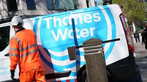 Worker standing in front of Thames Water van