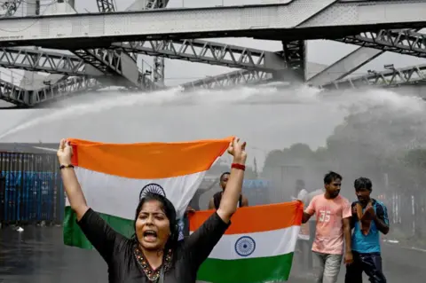 AFP Police use water canons to disperse activists carrying India's national flag as they march towards the state secretariat demanding the resignation of Mamata Banerjee, chief minister of the country's West Bengal state amid protests against the rape and murder of a doctor near Howrah bridge in Kolkata on August 27, 2024. 