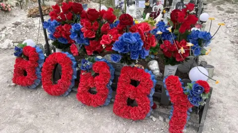 Family Handout Floral tribute in red and blue flowers which reads Bobby.
