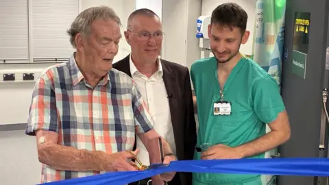 Rod Petman, trust chief executive Anthony May and Dr Andrew Baxter ribbon cutting at the entrance to the new unit
