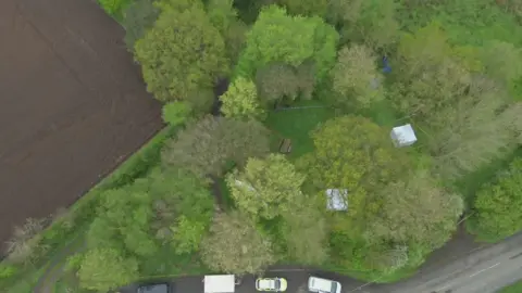 Cumbria Police An aerial view of the woods where Paul Taylor's body was found. There is police tape and tents.