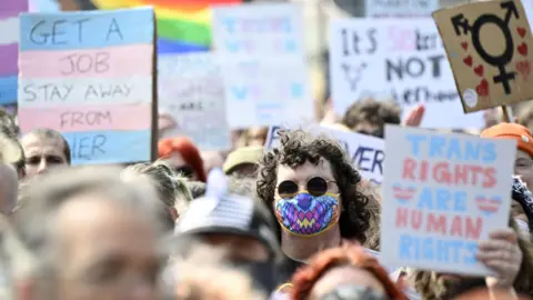 PA Media Trans rights supporters protest in Edinburgh, holding signs saying things like TRANS RIGHTS ARE HUMAN RIGHTS