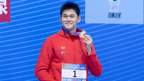 Chinese swimmer Sun Yang celebrates with gold medal after winning the Men's 400m freestyle final on day one of the 2024 National Summer Swimming Championships.