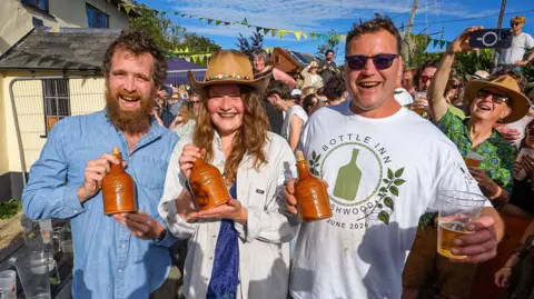 PA (left to right) Mental Health worker Jamie Giles, orchard worker Lucy Dermody, 23, and Michael Hobbs, winners in the World Stinging Nettles Eating Championships